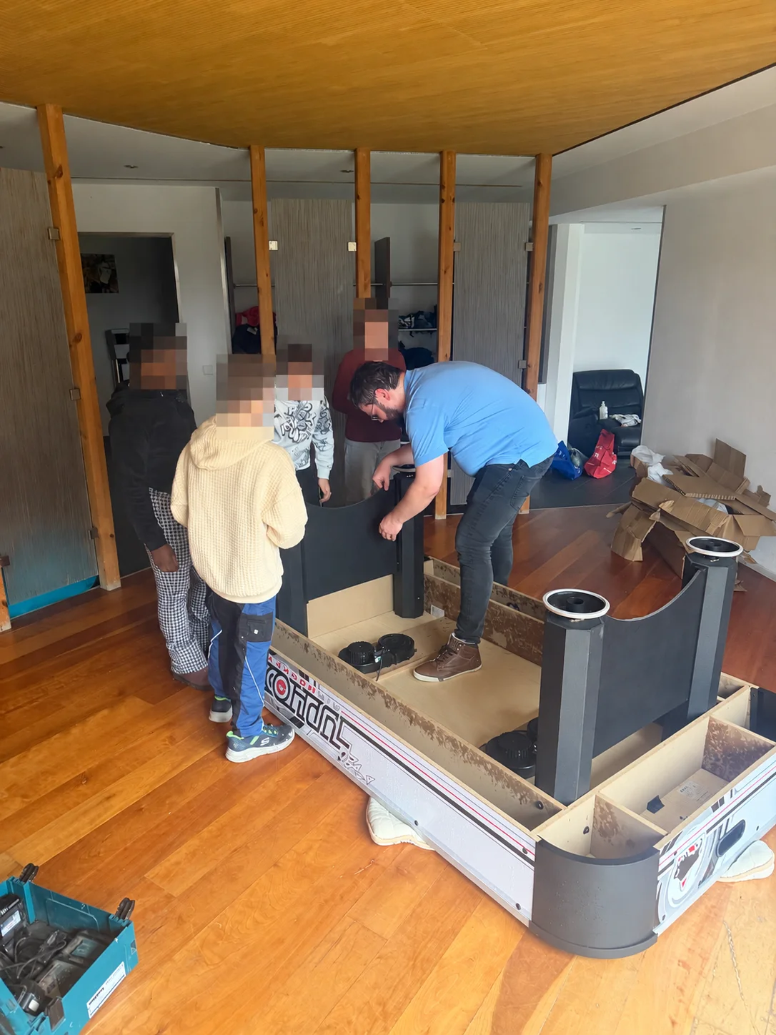 Assembling the air hockey table with the children; their faces have been obscured