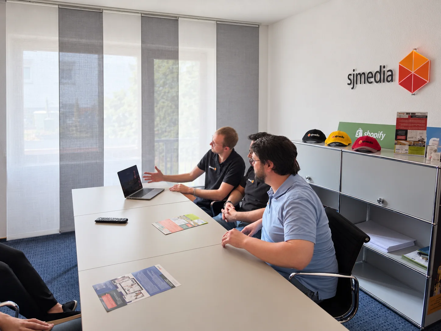 Drei sjmedia-Mitarbeiter im gemeinsamen Projektgespräch am Besprechungstisch
