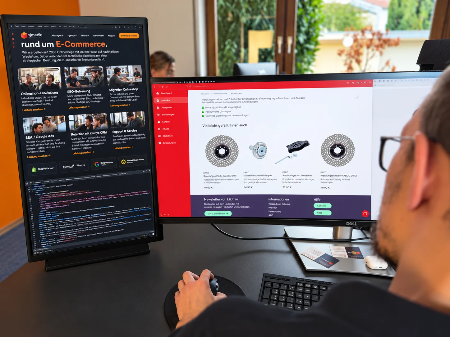 sjmedia-Mitarbeiter bei der Onlineshop-Entwicklung an zwei Monitoren