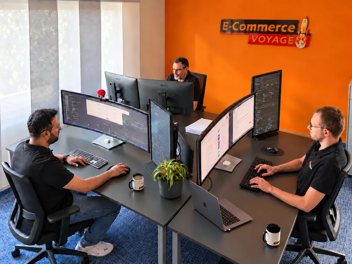Drei Mitarbeiter der sjmedia GmbH arbeiten gemeinsam an Onlineshop-Projekten im Büro in Kuppenheim